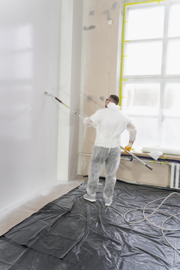joven-trabajador-pintando-pared-tiro-completo
